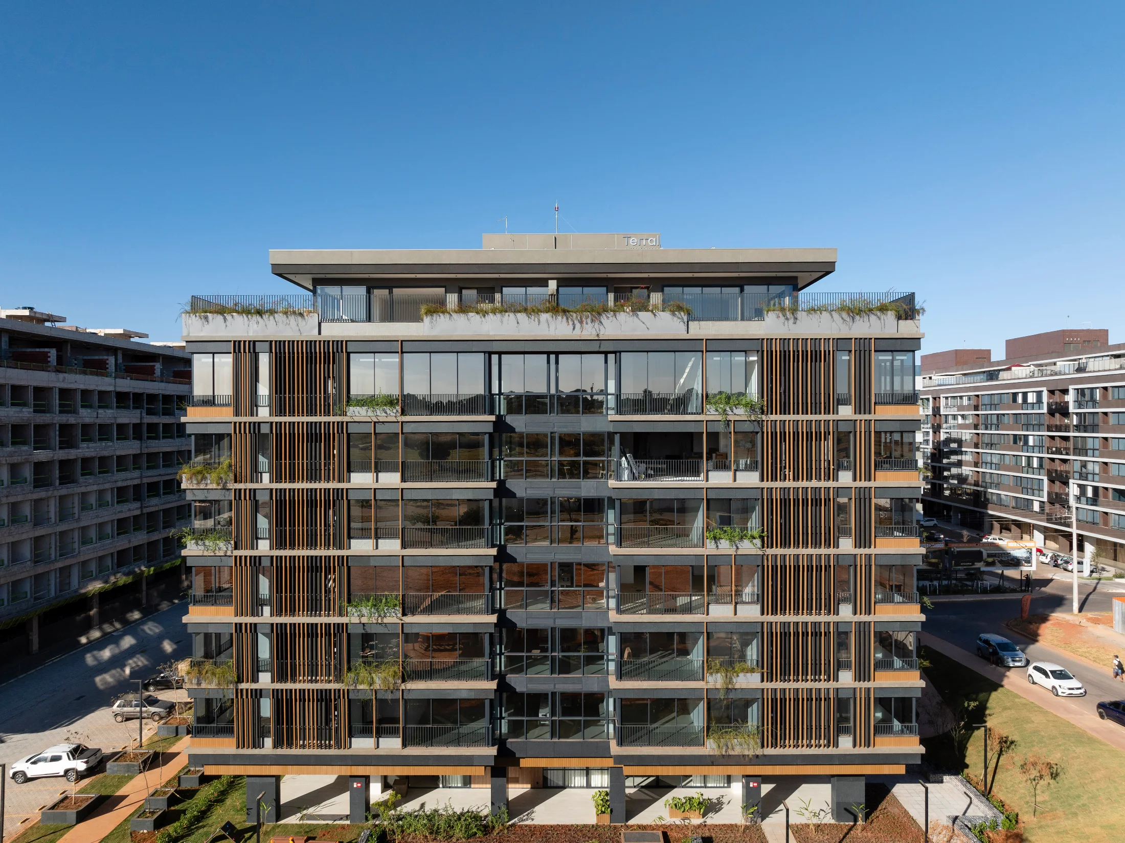 Edifício com fachada em madeira ecológica Lesco, brises verticais e sacadas plantadas.